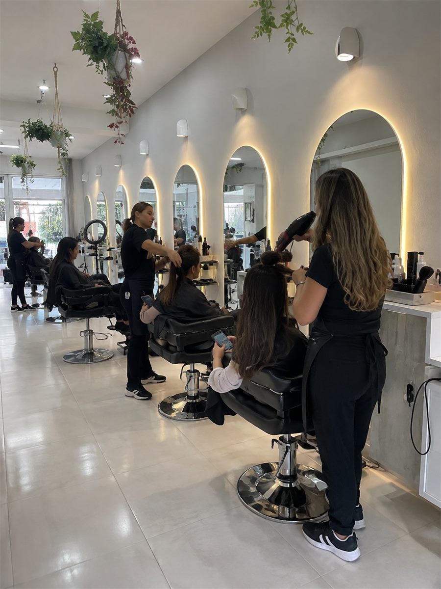 Estilistas peinando a varias clientas en un salón de belleza